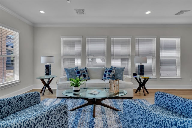 living room featuring a healthy amount of sunlight, ornamental molding, and hardwood / wood-style flooring