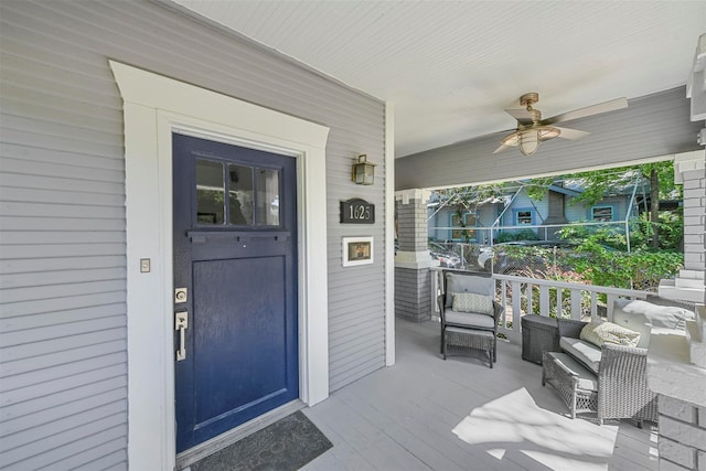 doorway to property featuring ceiling fan and a porch