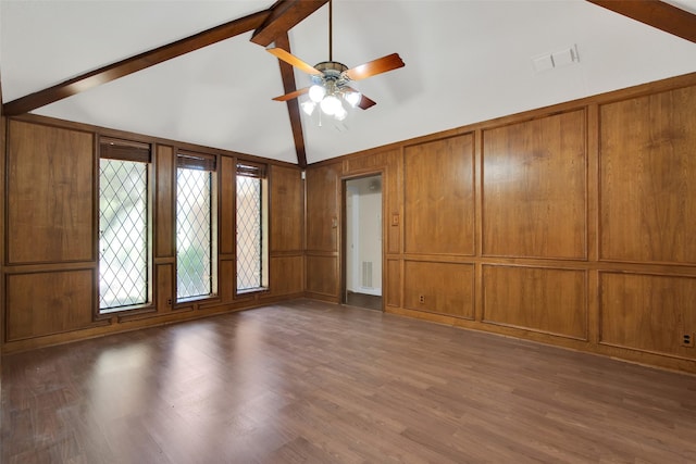 unfurnished living room with dark hardwood / wood-style flooring, lofted ceiling with beams, ceiling fan, and wood walls