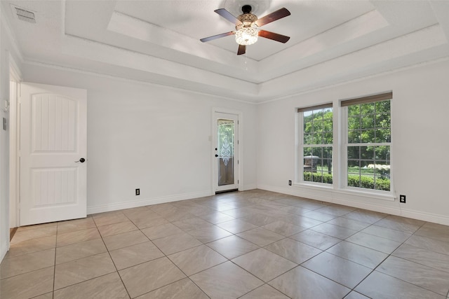 unfurnished room with ceiling fan, light tile patterned floors, and a tray ceiling