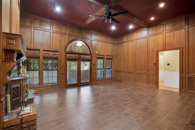 unfurnished living room with beamed ceiling, crown molding, ceiling fan, and coffered ceiling