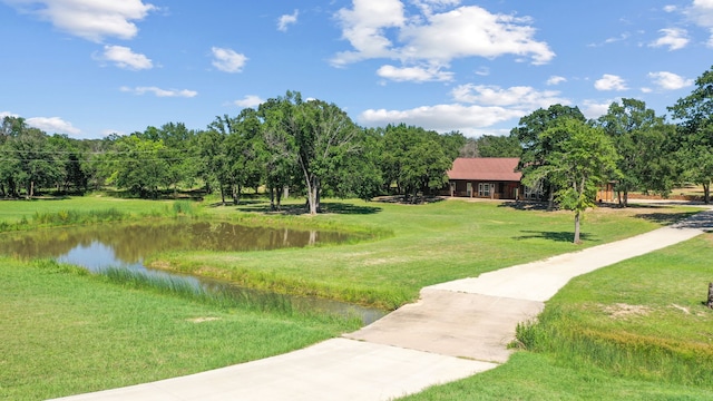 view of property's community with a yard and a water view