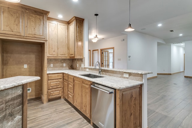 kitchen with dishwasher, kitchen peninsula, sink, and decorative light fixtures