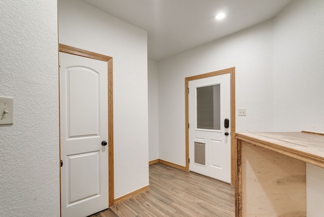 hallway with light hardwood / wood-style floors