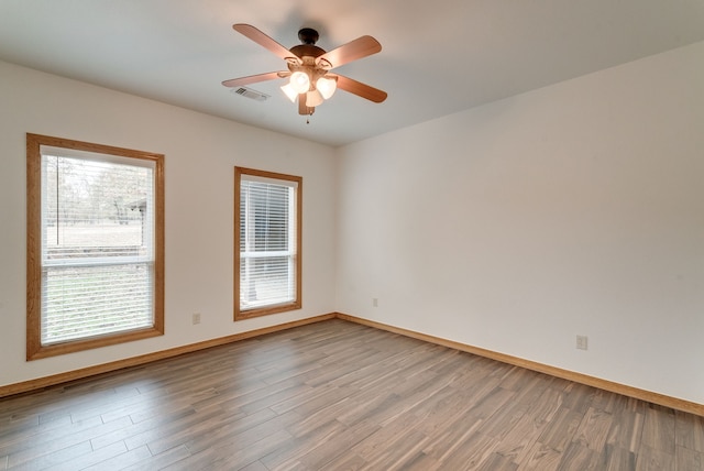 spare room featuring wood-type flooring and ceiling fan