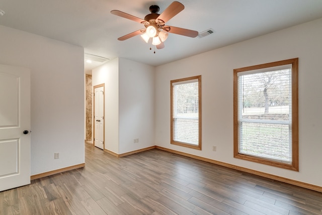 empty room with ceiling fan and light hardwood / wood-style floors