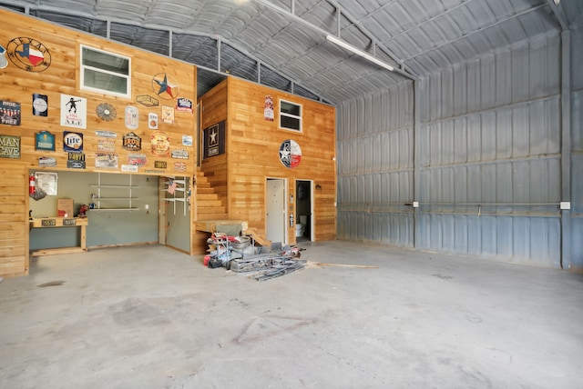 garage with a workshop area and wooden walls