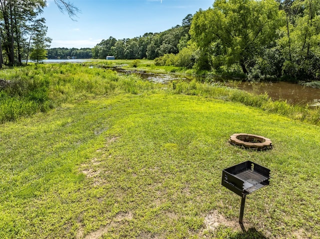 view of yard with a fire pit and a water view