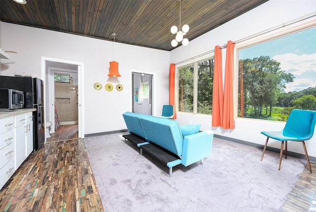 living room featuring an inviting chandelier, a wealth of natural light, wooden ceiling, and dark hardwood / wood-style flooring