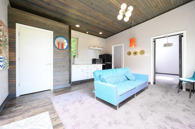 living room featuring sink, wooden ceiling, and wood walls