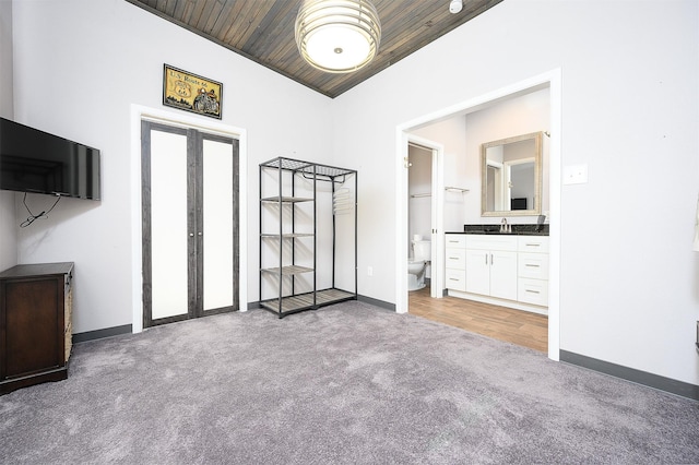 interior space featuring carpet floors, sink, wooden ceiling, ensuite bath, and french doors