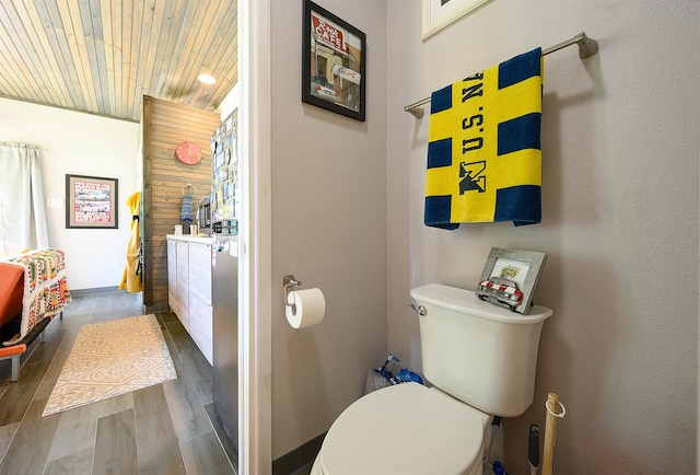 bathroom featuring wood-type flooring, wooden ceiling, and toilet