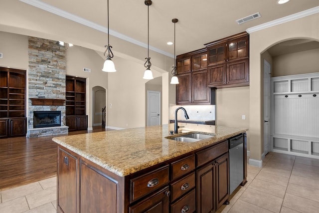 kitchen with visible vents, a sink, light tile patterned floors, arched walkways, and stainless steel dishwasher