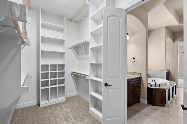 walk in closet featuring light colored carpet