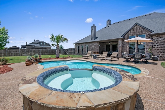 view of pool featuring a patio, a fenced backyard, and a pool with connected hot tub