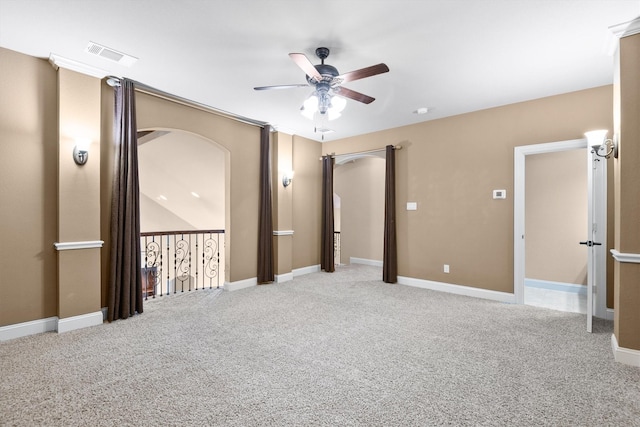 carpeted empty room featuring visible vents, baseboards, and ceiling fan