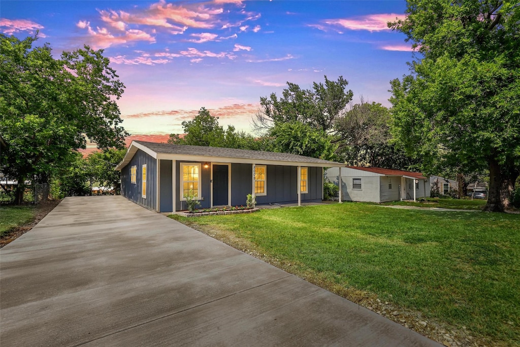 single story home featuring covered porch and a lawn