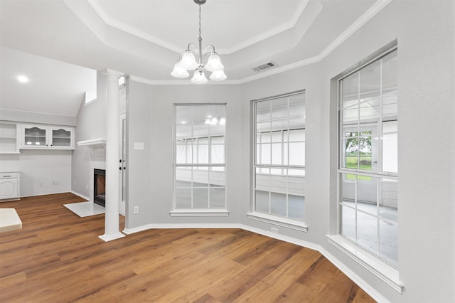 419 State Highway 205th Ext, Rockwall, TX 75032 - unfurnished dining area featuring wood finished floors, a tray ceiling, a chandelier, a fireplace with flush hearth, and crown molding