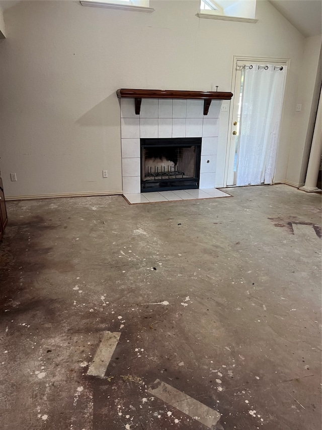 unfurnished living room with a high ceiling and a tiled fireplace