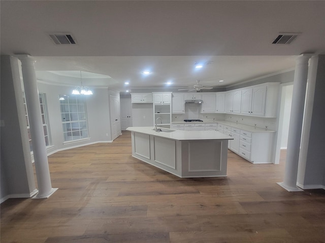 kitchen featuring crown molding, a sink, visible vents, and ornate columns