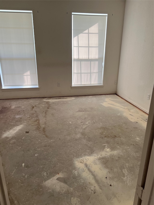 unfurnished room with concrete flooring