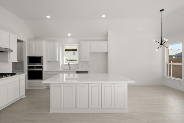 kitchen featuring sink, a kitchen island, stainless steel appliances, and vaulted ceiling