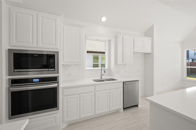 kitchen featuring a healthy amount of sunlight, white cabinetry, sink, and appliances with stainless steel finishes