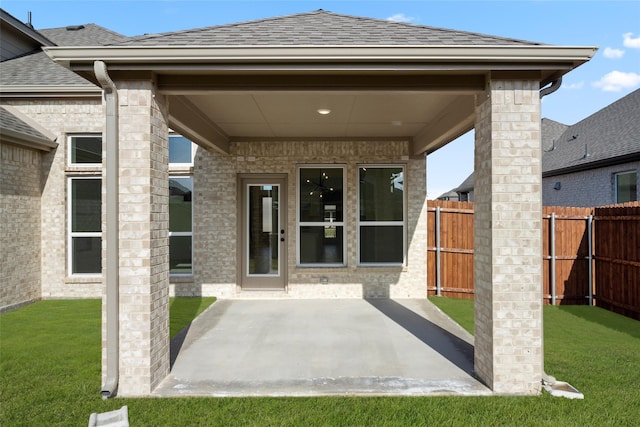 doorway to property featuring a patio and a lawn