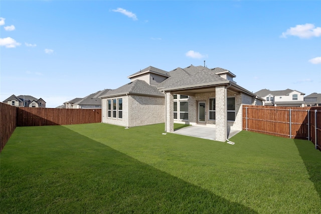 back of house with a patio area and a lawn