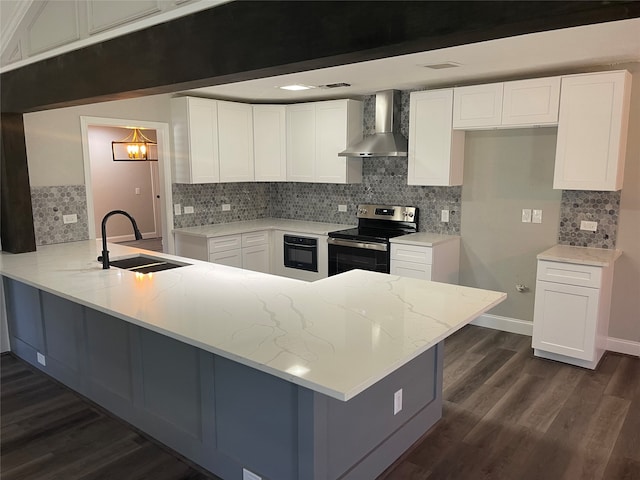 kitchen with electric stove, wall chimney range hood, sink, white cabinetry, and kitchen peninsula