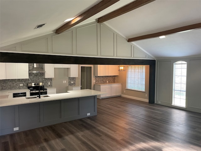 kitchen featuring vaulted ceiling with beams, wall chimney exhaust hood, dark wood-type flooring, and sink