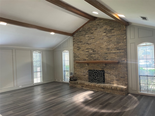 unfurnished living room featuring plenty of natural light, a fireplace, lofted ceiling with beams, and dark hardwood / wood-style floors