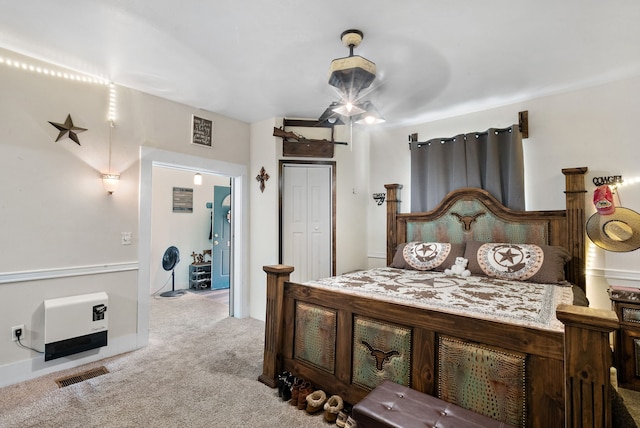 bedroom featuring ceiling fan, light colored carpet, and heating unit