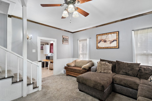 carpeted living room with ceiling fan and crown molding