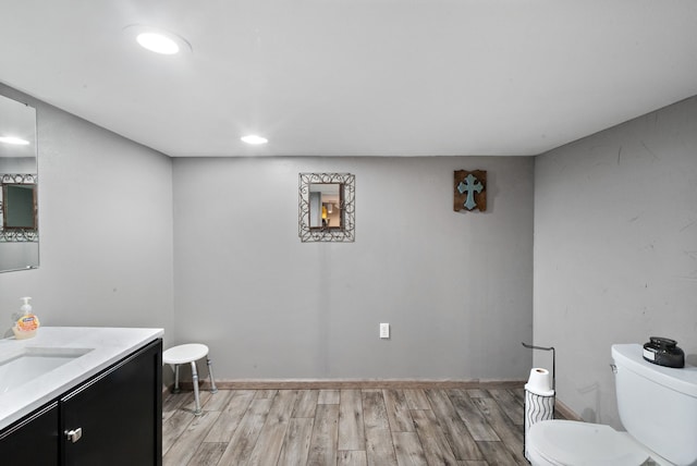 bathroom with hardwood / wood-style floors, vanity, and toilet