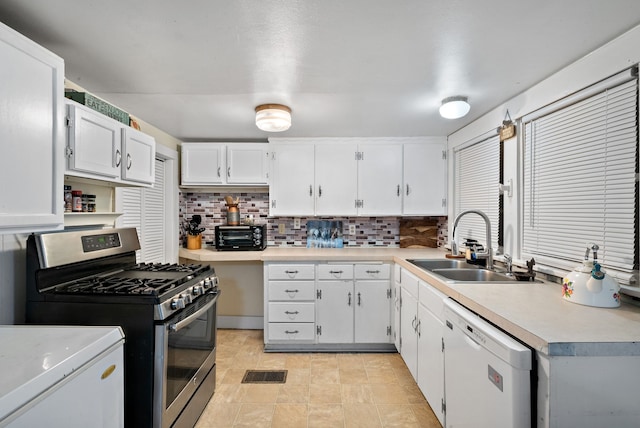 kitchen with dishwasher, sink, stainless steel gas range, tasteful backsplash, and white cabinetry