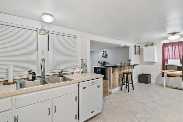 kitchen with white cabinetry, sink, and white dishwasher