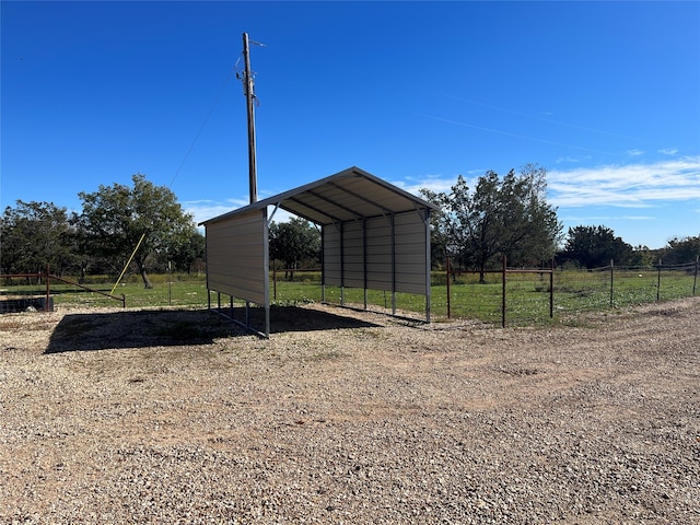 view of outdoor structure with a rural view and a carport