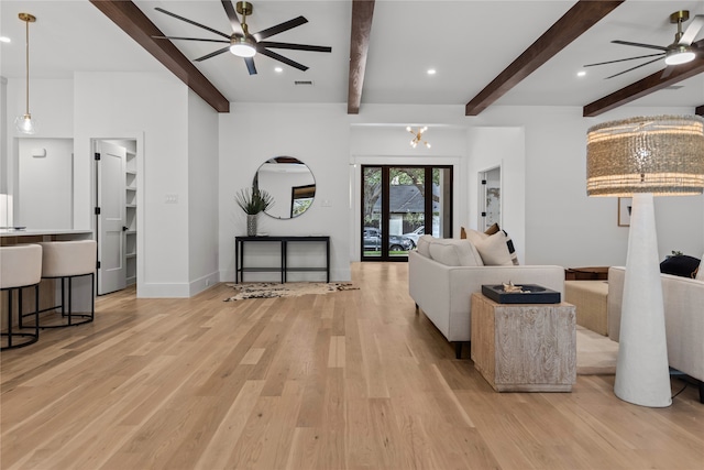 living room with beam ceiling, ceiling fan, and light wood-type flooring