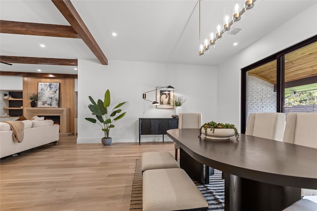 dining room with beam ceiling and light hardwood / wood-style floors