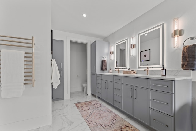 bathroom featuring vanity, radiator heating unit, and toilet