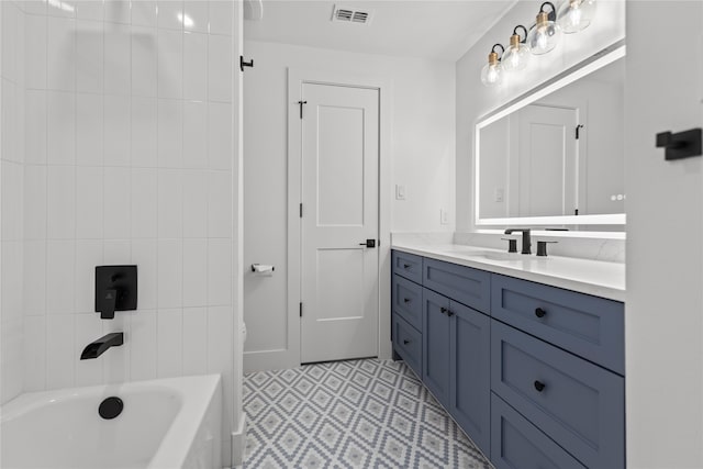 bathroom featuring vanity and tiled shower / bath