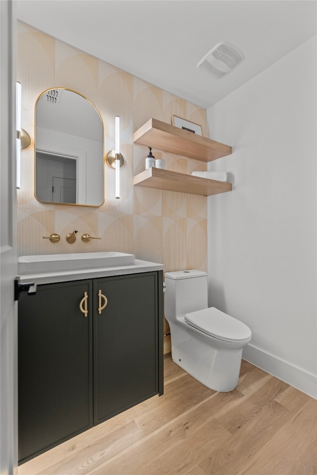 bathroom with vanity, toilet, and hardwood / wood-style floors