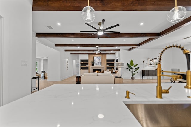 kitchen with sink, decorative light fixtures, and light stone countertops