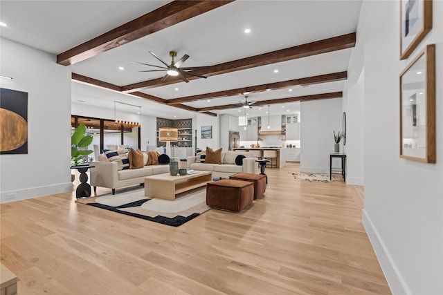 living room featuring ceiling fan, beam ceiling, and light hardwood / wood-style floors