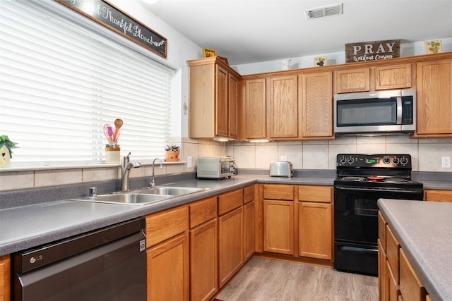 kitchen featuring tasteful backsplash, sink, black appliances, and light hardwood / wood-style floors