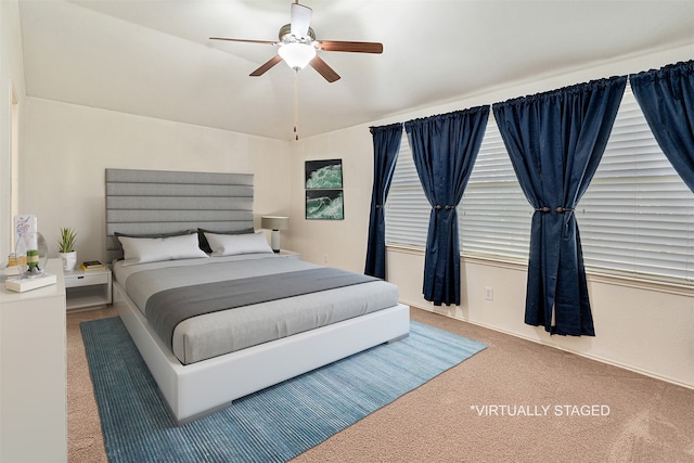 carpeted bedroom with multiple windows, lofted ceiling, and ceiling fan