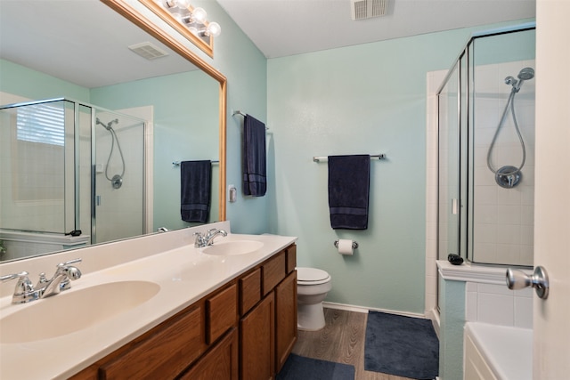 bathroom with vanity, toilet, a shower with door, and wood-type flooring