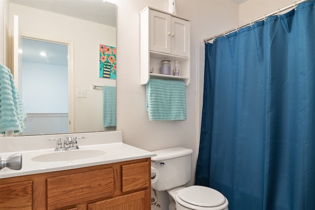 bathroom with vanity, walk in shower, and toilet