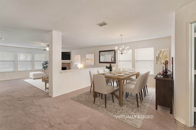 carpeted dining room featuring ceiling fan with notable chandelier and a textured ceiling